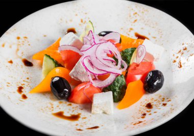 Yunan salata bir kase taze sebze ve beyaz peynir, siyah arka plan üzerine izole. Üstten görünüm