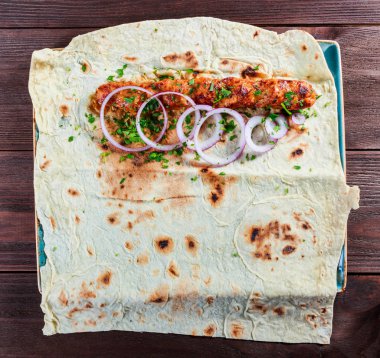 Tavuk kebap Pide, soğan ve koyu ahşap zemin üzerine yeşil. Şaşlık veya şiş kebap. Sağlıklı yemek