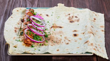 Tavuk kebap Pide, soğan ve koyu ahşap zemin üzerine yeşil. Şaşlık veya şiş kebap. Sağlıklı yemek