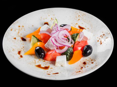 Yunan salata bir kase taze sebze ve beyaz peynir, siyah arka plan üzerine izole. Üstten görünüm