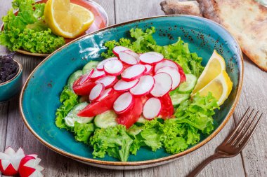 Turp, domates, salatalık, marul ve ahşap arka plan üzerinde şarap taze salata. Sağlıklı gıda. Üstten görünüm