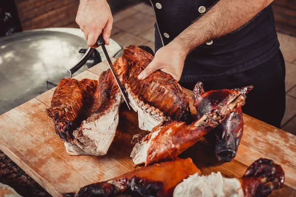 Chef Mãos Cortando Porco Grelhado Inteiro Para Bifes Com Faca — Fotografia de Stock