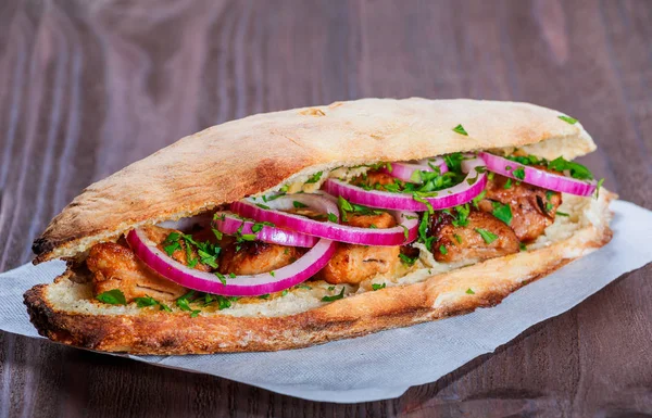 양파와 어두운 배경에 신선한 빵에서 샌드위치에 구운된 Shashlik 케밥입니다 — 스톡 사진