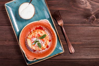 Tatlı peynir güveç ile reçel koyu ahşap zemin üzerine kapatın. Sıcak ve sağlıklı kahvaltı, üstten görünüm, düz yatıyordu