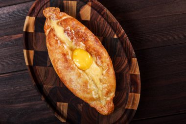 Acaralı Khachapuri geleneksel Gürcü peynir pasta kesme tahtası üzerinde yumurta ile. Homemade Pişirme. Üstten görünüm