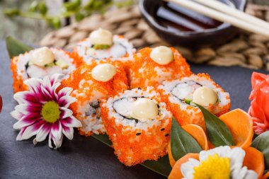 Suşi rulo - Maki Sushi sashimi çiçeklerle süslenmiş. Japon mutfağı. Seçici odak