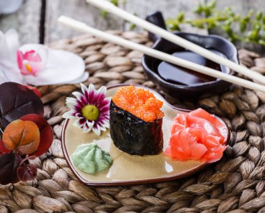 Suşi Gunkan maki ile bambu hasır, seçici odak üzerinde kalp şeklinde tabakta somon havyar. Japon mutfağı