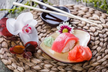 Suşi Set nigiri ve suşi rulo bambu zemin üzerine çiçeklerle süslenmiş. Japon mutfağı. Seçici odak