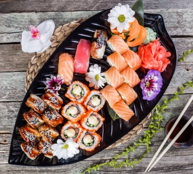 Suşi Set nigiri ve suşi rulo Bambu zemin üzerine çiçeklerle süslenmiş. Japon mutfağı. Üstten görünüm