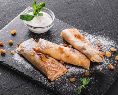 Tofu peyniri, pesto sos ve plaka üzerinde roka ile doldurulmuş krep. Bir koyu gri taş yüzeye görüntüleyin. Sağlıklı kahvaltı