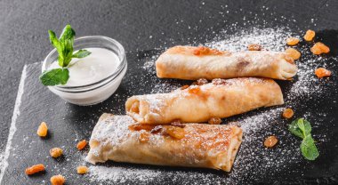 Tofu peyniri, pesto sos ve plaka üzerinde roka ile doldurulmuş krep. Bir koyu gri taş yüzeye görüntüleyin. Sağlıklı kahvaltı