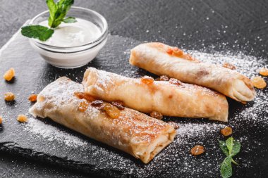 Tofu peyniri, pesto sos ve plaka üzerinde roka ile doldurulmuş krep. Bir koyu gri taş yüzeye görüntüleyin. Sağlıklı kahvaltı