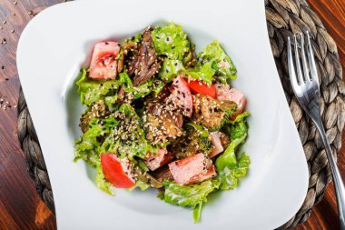 Sıcak Salata tavuk karaciğer, domates, marul yaprakları, brokoli ahşap masa üzerinde. Sağlıklı gıda. Üstten görünüm