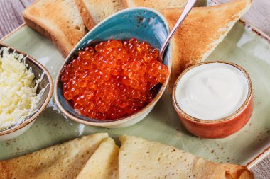 Krep kırmızı havyar, tereyağı ve plaka üzerinde ekşi krema ile kapatın. Hafta ya da Shrovetide krep geleneksel Rus mutfağı. Düz yatıyordu. Üstten görünüm