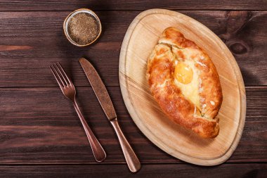 Acaralı Khachapuri geleneksel Gürcü peynir pasta kesme tahtası üzerinde yumurta ile. Homemade Pişirme. Üstten görünüm