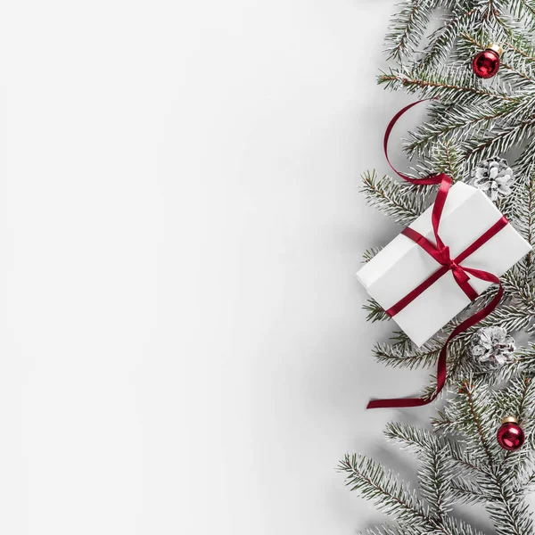 圣诞礼品盒在白色背景与冷杉分枝 红色丝带 圣诞节和新年快乐主题 平面布局 顶部视图 — 图库照片
