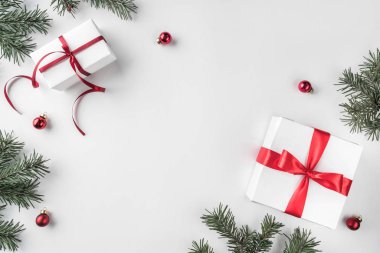 Yaratıcı çerçeve Noel köknar yapılan Beyaz Kağıt arka plan kırmızı süslemeli, çam kozalakları dallarda. Noel ve yeni yıl tema. Düz yatıyordu, en iyi görünümü