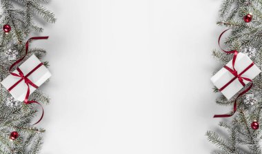 Yaratıcı çerçeve Noel köknar yapılan Beyaz Kağıt arka plan kırmızı süslemeli, çam kozalakları dallarda. Noel ve yeni yıl tema. Düz yatıyordu, en iyi görünümü