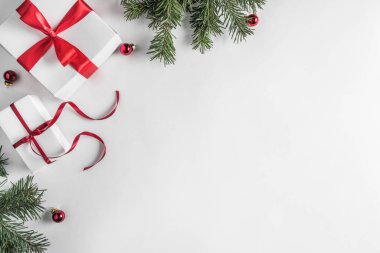 Yaratıcı çerçeve Noel köknar yapılan Beyaz Kağıt arka plan kırmızı süslemeli, çam kozalakları dallarda. Noel ve yeni yıl tema. Düz yatıyordu, en iyi görünümü