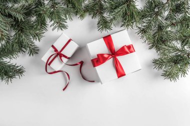 Noel hediye kutuları ve çam dalları Beyaz Kağıt arka plan üzerinde yaratıcı çerçeve yaptı. Noel ve mutlu yeni yıl tema. Düz yatıyordu, en iyi görünümü