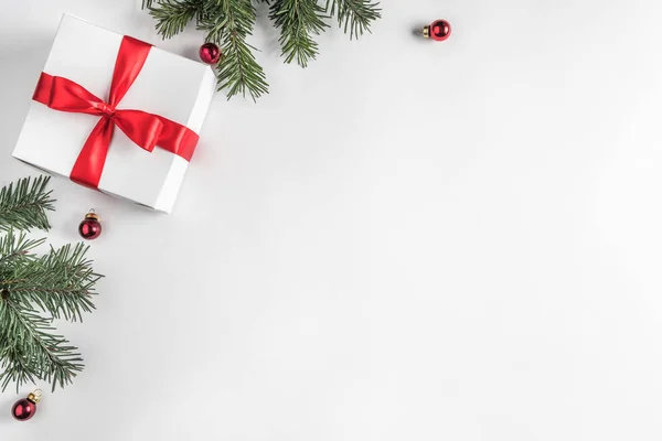 Yaratıcı çerçeve Noel köknar yapılan Beyaz Kağıt arka plan kırmızı süslemeli, çam kozalakları dallarda. Noel ve yeni yıl tema. Düz yatıyordu, en iyi görünümü