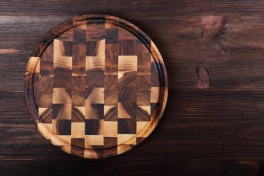 Koyu arka plan üzerinde ahşap kesim kurulu. Üstten görünüm