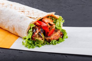 Izgara sebze ve marul üzerine koyu ahşap arka plan vejetaryen Burrito sarar. Sağlıklı yemek