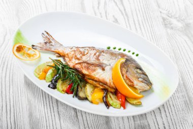 Izgara dorado balık pişmiş sebze ve biberiye plaka ahşap zemin üzerine kapatın. Sağlıklı gıda. Üstten görünüm