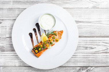 Peynir soslu somon balığı fırında, biberiye ve limon ahşap zemin üzerine kapatalım. Sıcak balık yemek