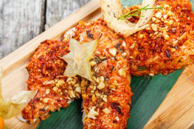 Kızarmış deniz balık fileto physalis ve badem kesme tahtası üzerinde ile kapatın. Sıcak balık yemek