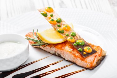 Peynir soslu somon balığı fırında, biberiye ve limon ahşap zemin üzerine kapatalım. Sıcak balık yemek