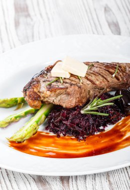 Tatlım, biberiye, kuşkonmaz ve pancar salatası ahşap arka plan üzerinde tarihleri ızgara domuz eti biftek. Sıcak et yemekleri. Üstten görünüm, düz yatıyordu