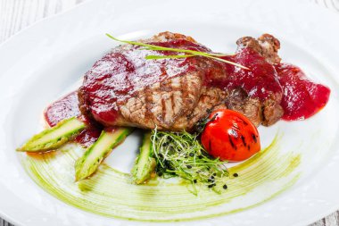 Izgara antrikot Biftek Biftek berry sos, kuşkonmaz ve brokoli hafif ahşap zemin üzerinde. Sıcak et yemekleri. Üstten görünüm, düz yatıyordu