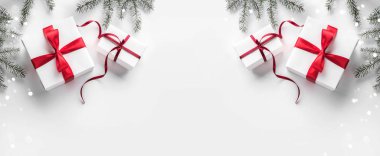 Yaratıcı çerçeve Noel köknar yapılan Beyaz Kağıt arka plan kırmızı süslemeli, çam kozalakları dallarda. Noel ve yeni yıl tema, kar taneleri, bokeh. Düz yatıyordu, en iyi görünümü