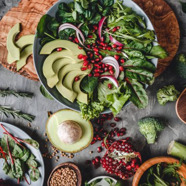 Avokado, yeşillik, roka, ıspanak ve nar içeren sağlıklı taze salata. Sağlıklı vejetaryen yemekleri, temiz yemek, perhiz, üst manzara.