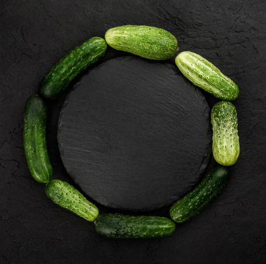 Salatalık siyah arka plan üzerine yapılmış yaratıcı düzeni. Sağlıklı gıda kavramı, üstten görünüm, düz yatıyordu, kopyalama alanı