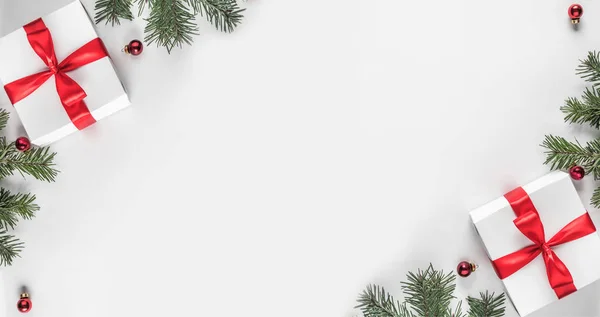 创意框架由圣诞冷杉树枝在白纸背景与红色装饰 礼品盒 圣诞节和新年主题 平面布局 顶部视图 — 图库照片