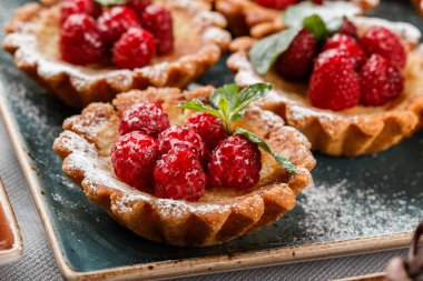 Ahududu ve krem, kek ve tatlılık tatil arka plan ile meyve tart. Lezzetli tatlı ve şeker çubuğu