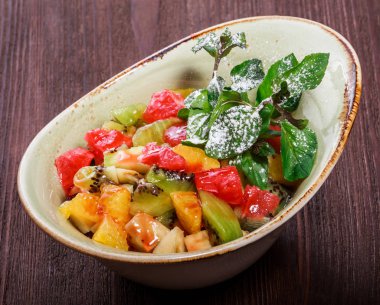 Muz, kivi, portakal, greyfurt, plaka üzerinde ananas meyve salatası. Sağlıklı kahvaltı