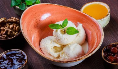 Vanilyalı dondurma kaşık toz kase nane yaprakları üzerinde ahşap arka plan