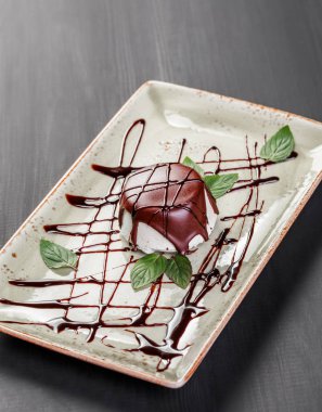 Vanilyalı dondurma plaka üzerinde çikolata ve nane yaprakları ile