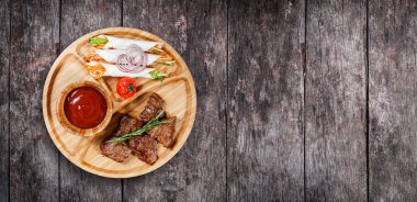 Izgara et ve sebze taze salata ve kesme tahtası üzerinde ahşap arka plan barbekü sosu ile kapatın. Sıcak et yemekleri. Üstten Görünüm