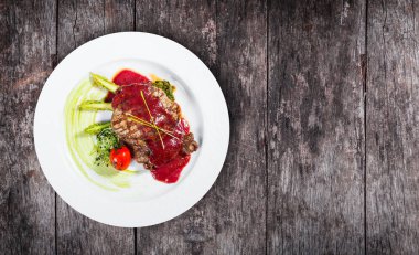 Izgara antrikot Biftek Biftek berry sos, kuşkonmaz ve brokoli hafif ahşap zemin üzerinde. Sıcak et yemekleri. Üstten görünüm, düz yatıyordu