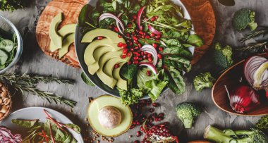 Sağlıklı taze salata avokado, Yeşiller, roka, ıspanak, plaka gri arka plan üzerine nar ile. Sağlıklı vegan gıda, temiz beslenme, diyet, en iyi görünüm, tonlama