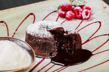 Çikolatalı kek veya fondan ahududu ve vanilyalı dondurma topu plaka, tatlı gıda ile