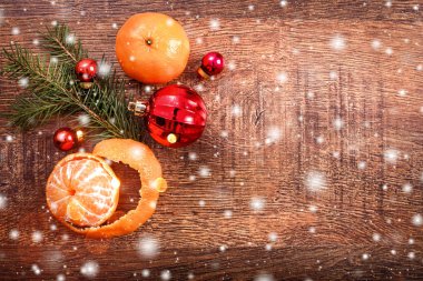 Noel süsleri çam ağacı dalı ve kar, bulanık, ahşap zemin üzerine mandalina ile kıvılcım. Noel ve mutlu yeni yıl kartı