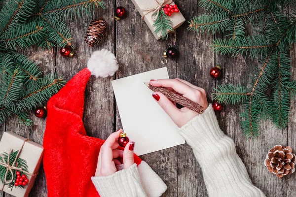 Ręka Pisze List Santa Drewniane Tła Prezenty Gałęzie Jodły Szyszki — Zdjęcie stockowe