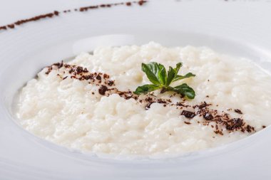 Pirinç lapası plaka gri arka plan üzerine rendelenmiş çikolata ile. Sağlıklı kahvaltı malzemeler. Yeme, vegan gıda kavramı temiz