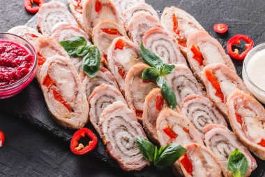 Çeşitli et, tavuk dolması rulo, et rulo ile biber, yeşillik siyah şeyl arka plan üzerinde. Et iştah açıcı, gıda kavramı. Üstten görünüm, düz yatıyordu