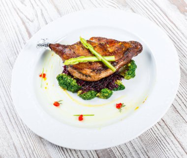 Kuşkonmaz ile kemik ızgara domuz eti biftek ve brokoli hafif ahşap zemin üzerine kapatın. Sıcak et yemekleri. Üstten görünüm